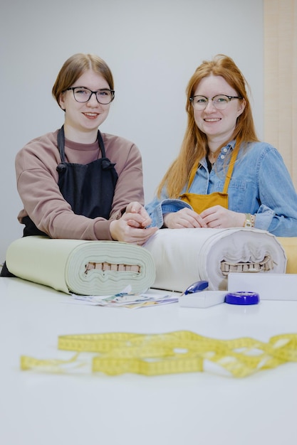 Happy students showing embroidered pieces